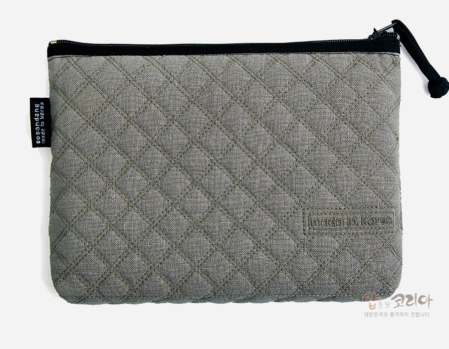 [텍스트: segodang made in korea, Made in Korea, 샵오브코리아 대한민국의 품격까지 전합니다.] 회색 누비 원단에 다이아몬드 퀼팅 기법을 더한 직사각형 파우치, 상단 흑색 지퍼와 끈 장식 포인트 디자인