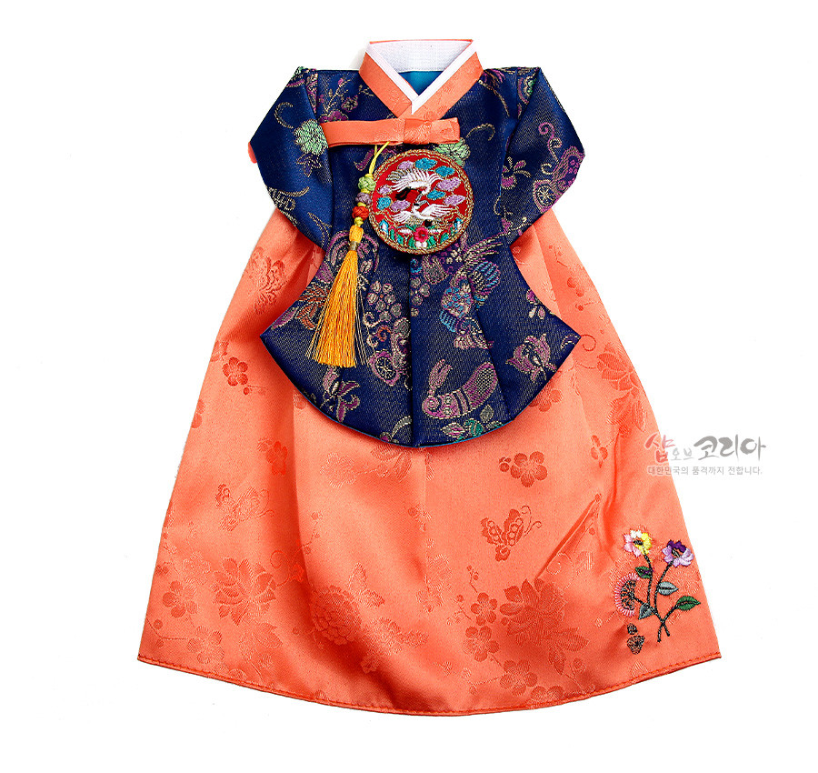 [텍스트: 샵오브코리아 대한민국의 품격까지 전합니다.] 주홍색 비단 치마에 꽃·나비 문양 자수, 남색 비단 당의에 다채로운 문양 직조와 원형 학 수자수 노리개·노란 술 장식이 어우러진 한복 형태 와인커버 이미지 설명