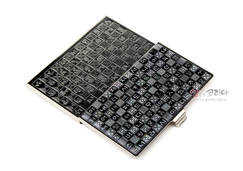 [텍스트: 샵오브코리아 대한민국의 품격까지 전합니다.] 검은 바탕 금속 명함케이스, 자개로 표현한 훈민정음 자모 격자 문양, 은빛 프레임 포인트 디자인