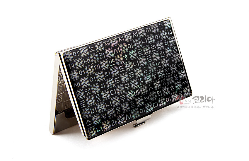 [텍스트: 샵오브코리아 대한민국의 품격까지 전합니다.] 검은 옻칠 바탕 위 자개 상감으로 훈민정음 자모를 격자 패턴으로 배열한 메탈 명함케이스 디자인