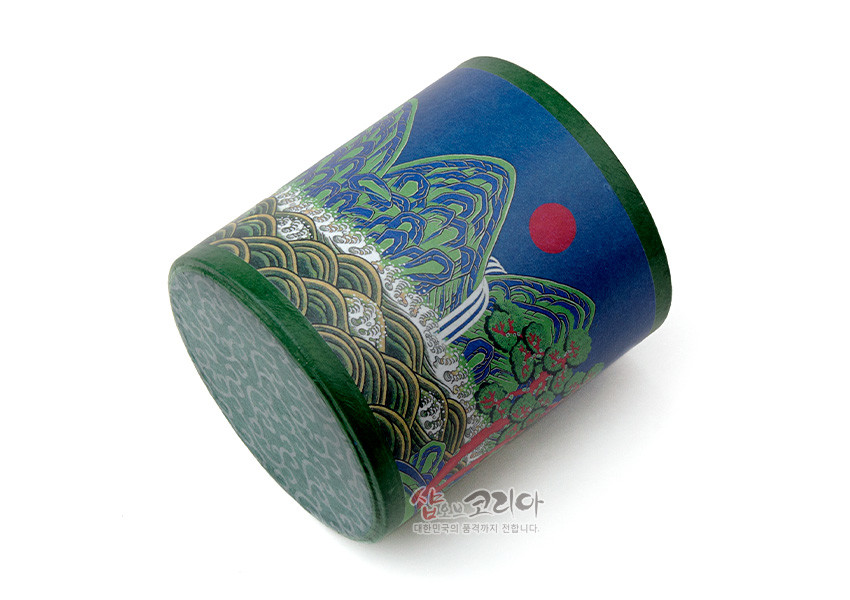 [텍스트: 샵오브코리아 대한민국의 품격까지 선물합니다.] 짙은 남색 바탕에 녹색·금색 위주의 일월오봉도 산수문을 둘러 채색한 종이 재질 원통형 펜꽂이 모습