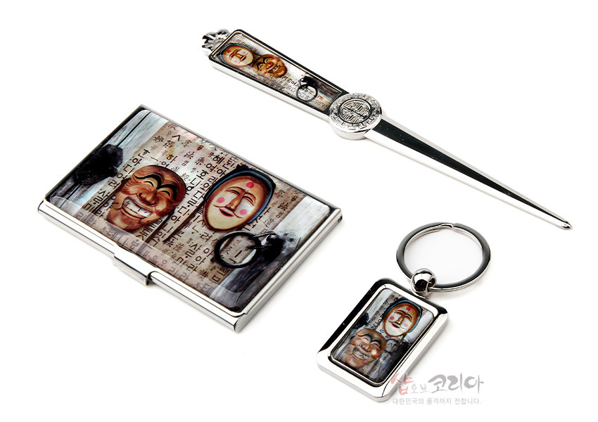 [텍스트: 하회탈과 한글 배경] 금속 재질 위에 컬러 인쇄된 하회탈 3종과 한글 서체 문양이 장식된 명함집·편지칼·열쇠고리 세트 이미지 설명