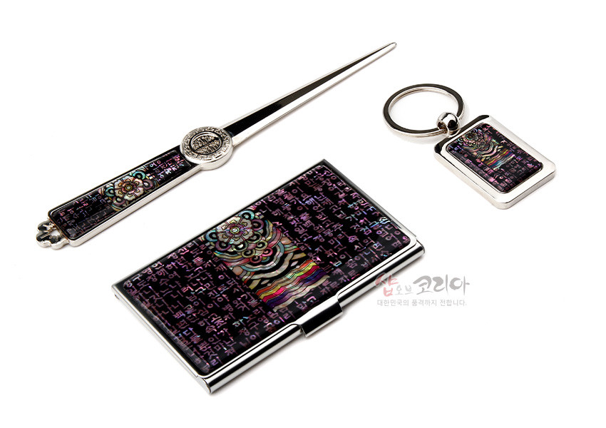 [텍스트: 남손 코리안 대한민국의 품격까지 전합니다.] 금속 틀에 보라색 바탕 자개 상감, 시조 한글 문자와 단청 연꽃·오방색 문양이 조화된 명함집·편지칼·열쇠고리 3종 세트 이미지