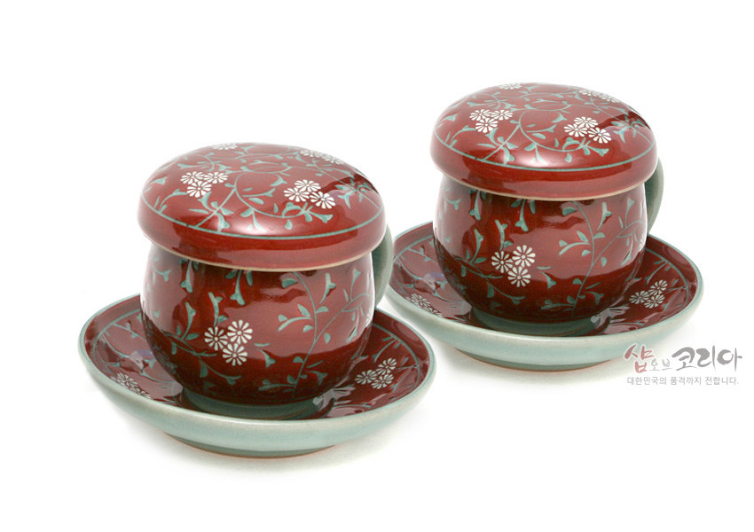 [텍스트: 샵오브코리아 대한민국의 품격까지 전합니다.] 진사색 도자기에 청록색 넝쿨과 백색 국화 문양을 장식한 뚜껑잔과 받침이 조화를 이룬 2인용 다기잔세트 이미지 설명