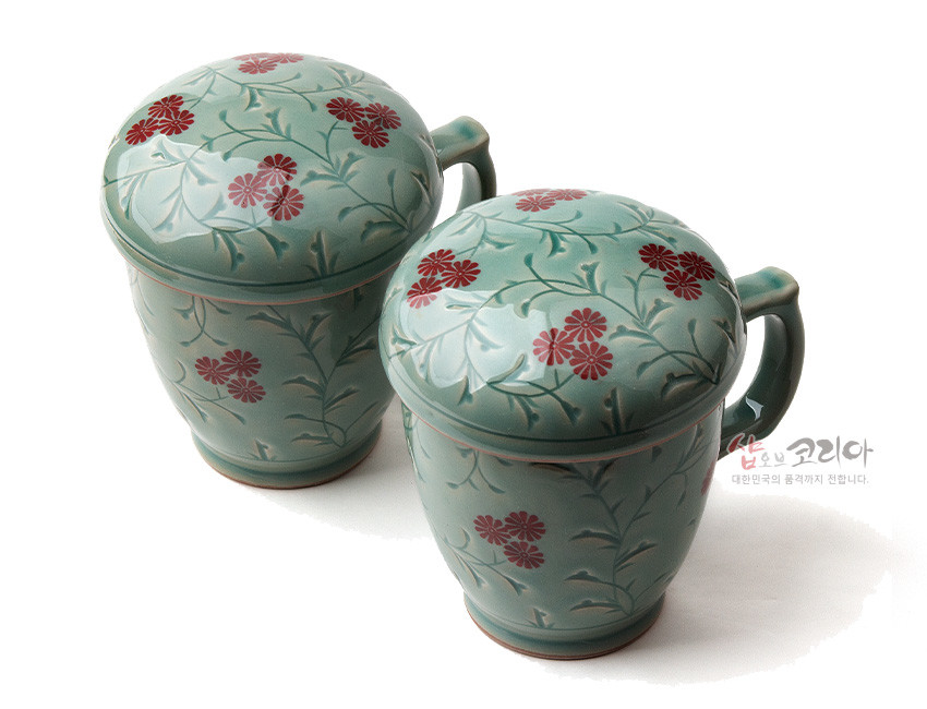 [텍스트: 샵오브코리아 대한민국의 품격까지 전합니다.] 청자 재질에 상감기법으로 새긴 붉은 국화와 초화문을 장식한 뚜껑 머그 다기잔 세트 이미지 설명