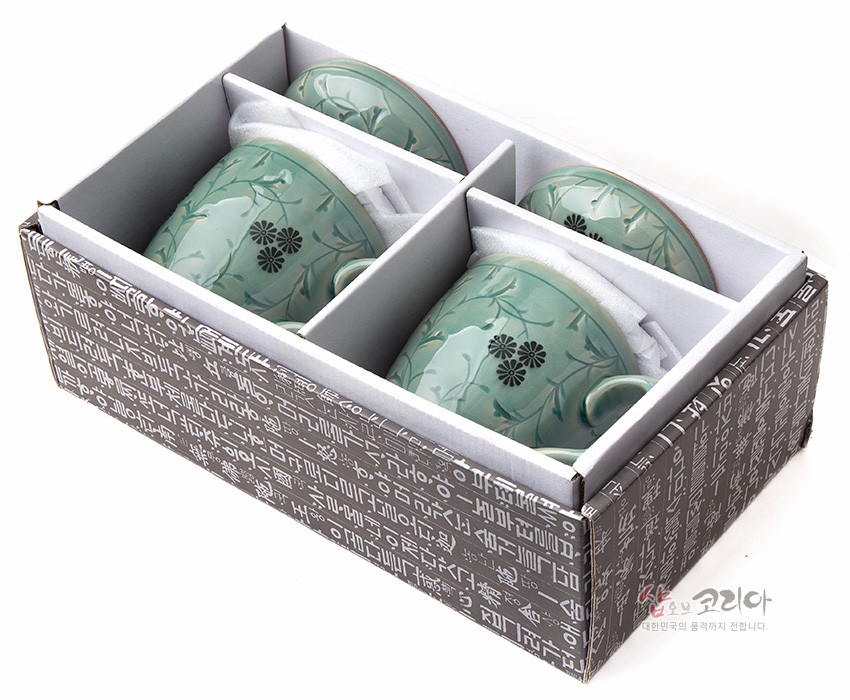 [텍스트: 샵오브코리아 대한민국의 품격까지 전합니다.] 상감 기법의 청자 재질, 흑색 국화와 담녹색 덩굴무늬가 새겨진 머그 다기잔 세트가 칸막이 포장 상자에 담긴 구성