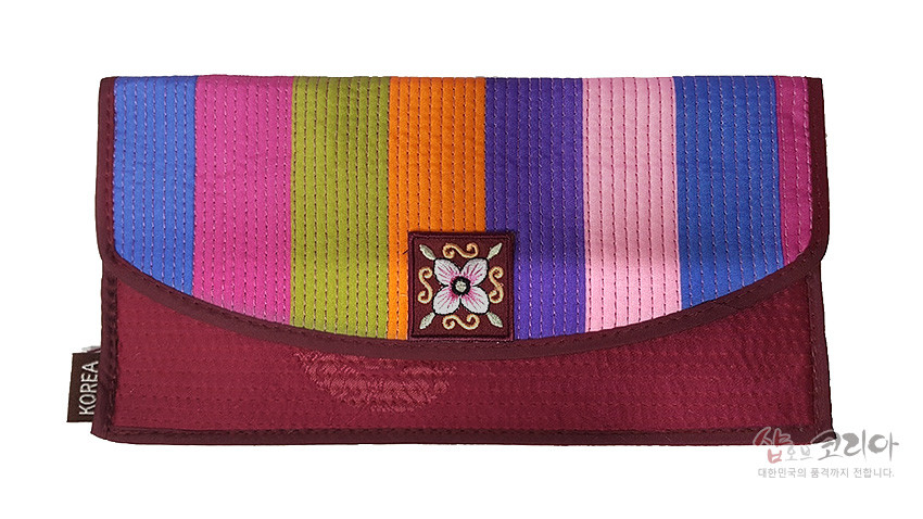 [텍스트: KOREA] 적갈색 누비 원단 바탕에 파랑·분홍·연두·주황·보라·연분홍 색동 누빔 배색과 중앙 꽃 자수 장식이 조화로운 장지갑 디자인