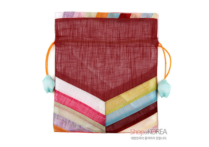 [텍스트: ShopofKOREA 대한민국의 품격까지 전합니다.] 붉은 모시 바탕에 사선 색동 패치워크와 노란 끈, 민트색 매듭 장식이 조화된 전통 복주머니 이미지