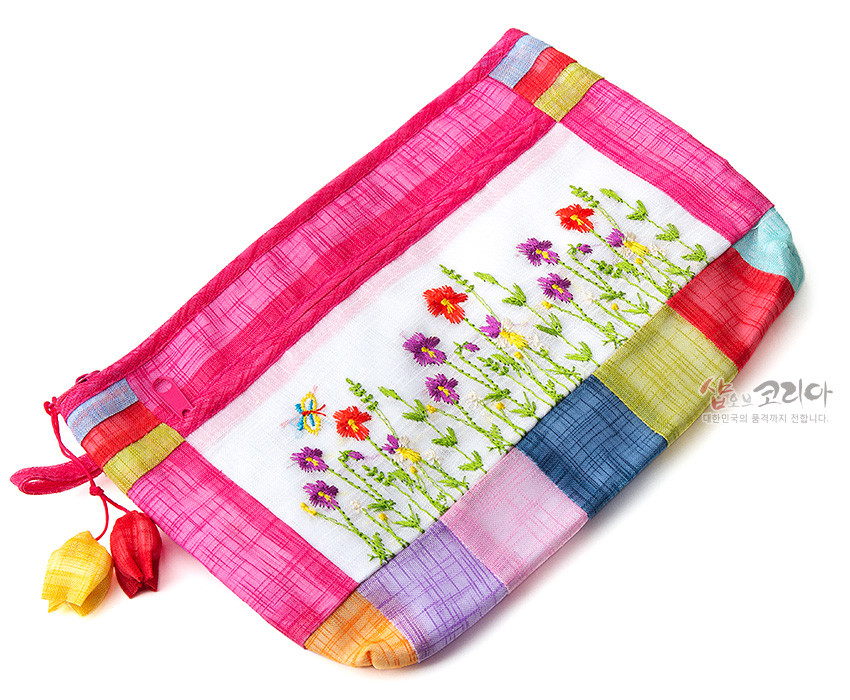 [텍스트: 샵오브코리아 대한민국의 품격까지 전합니다.] 분홍 모시와 다색 모시 조각을 배색하고 들꽃과 나비 자수를 놓은 직사각 지퍼 파우치, 색동 매듭 장식 특징