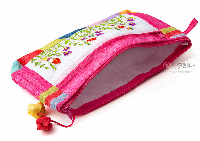 [텍스트: 샵오브코리아 대한민국의 품격까지 전합니다.] 분홍 모시 천에 흰색 모시 패널을 두고 들꽃 자수 놓인 지퍼 파우치, 사방 색동 모시 배색과 두 색상 조롱박 매듭 장식 구성