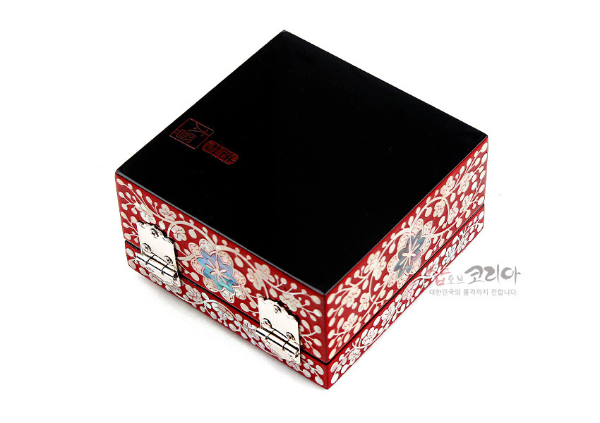 [텍스트: 샵오브코리아 대한민국의 품격까지 전합니다.] 붉은 옻칠 바탕에 자개 상감으로 당초무늬와 꽃문양을 촘촘히 장식하고, 금속 잠금장식을 더한 사각 정보석함 모습