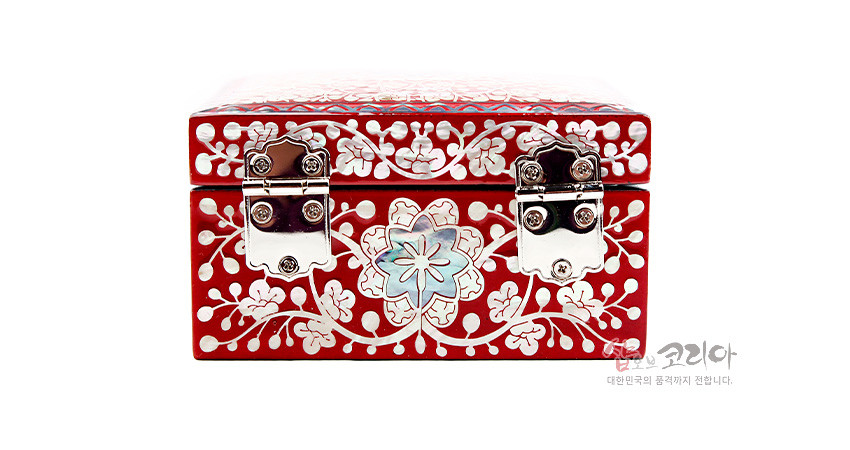 [텍스트: 샵오브코리아 대한민국의 품격까지 전합니다.] 붉은 옻칠 바탕 위 자개 상감으로 당초무늬와 꽃문양을 촘촘히 넣고 은빛 금속 잠금장식을 더한 사각 정보석함 모습