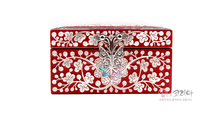 [텍스트: 샵오브코리아 대한민국의 품격까지 전합니다.] 붉은 옻칠 바탕에 자개 상감으로 당초무늬와 꽃문양을 촘촘히 새기고 금속 나비 장식 잠금장치를 더한 직사각 정보석함 이미지 설명
