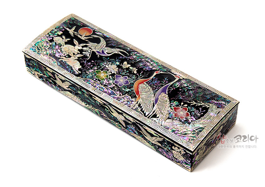 [텍스트: 샵오브코리아 대한민국의 품격까지 전합니다.] 흑색 옻칠 바탕 위 자개 상감 기법으로 송학과 해, 구름, 꽃 문양을 오색으로 장식한 직사각 나전 필함 모습