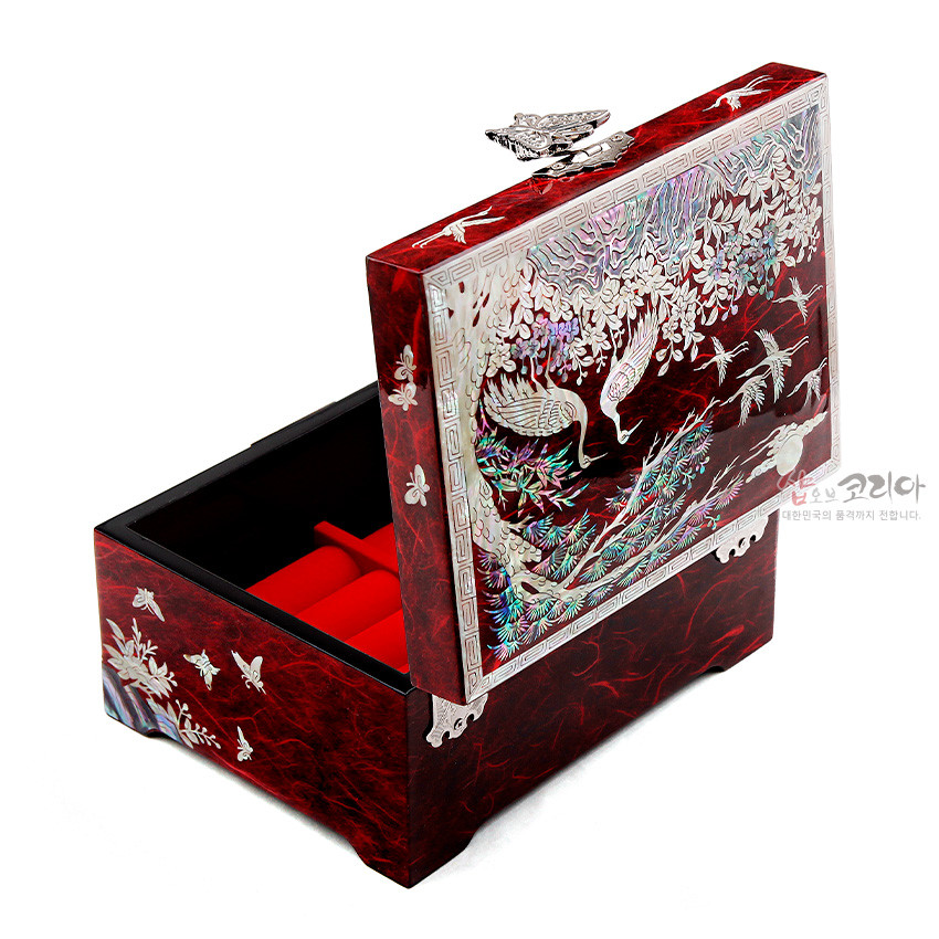 [텍스트: 샵오브코리아] 적색 옻칠 바탕 위 자개 상감 기법으로 송학과 소나무, 매화, 나비 문양을 정교하게 새긴 직사각 한지 보석함 내부 적색 칸막이 구성