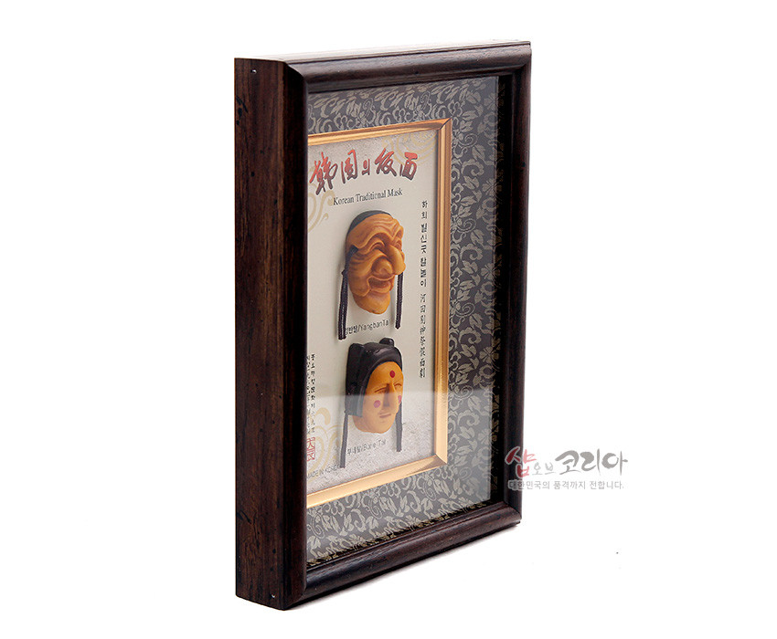 [텍스트: Korean Traditional Mask] 짙은 목재 액자에 금색 테두리와 회색 당초문 양단 배경을 두고 노란빛 하회탈 입체 장식이 세로로 배치된 구성
