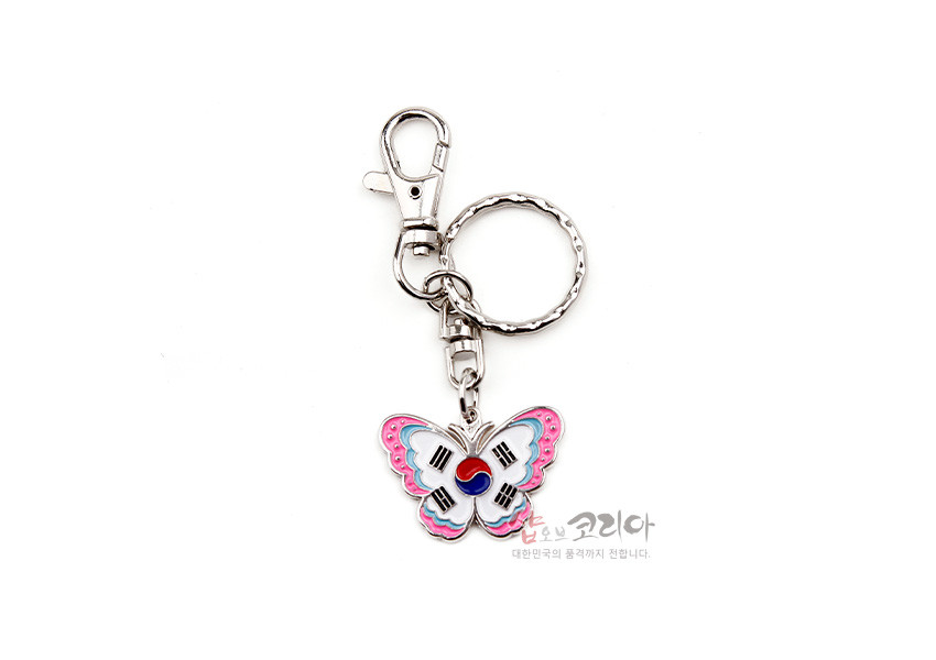 [텍스트: 샵오브코리아 대한민국의 품격까지 전합니다.] 금속 재질 나비 모양 펜던트에 태극기 문양과 분홍·하늘색 에나멜 채색이 더해진 열쇠고리 디자인