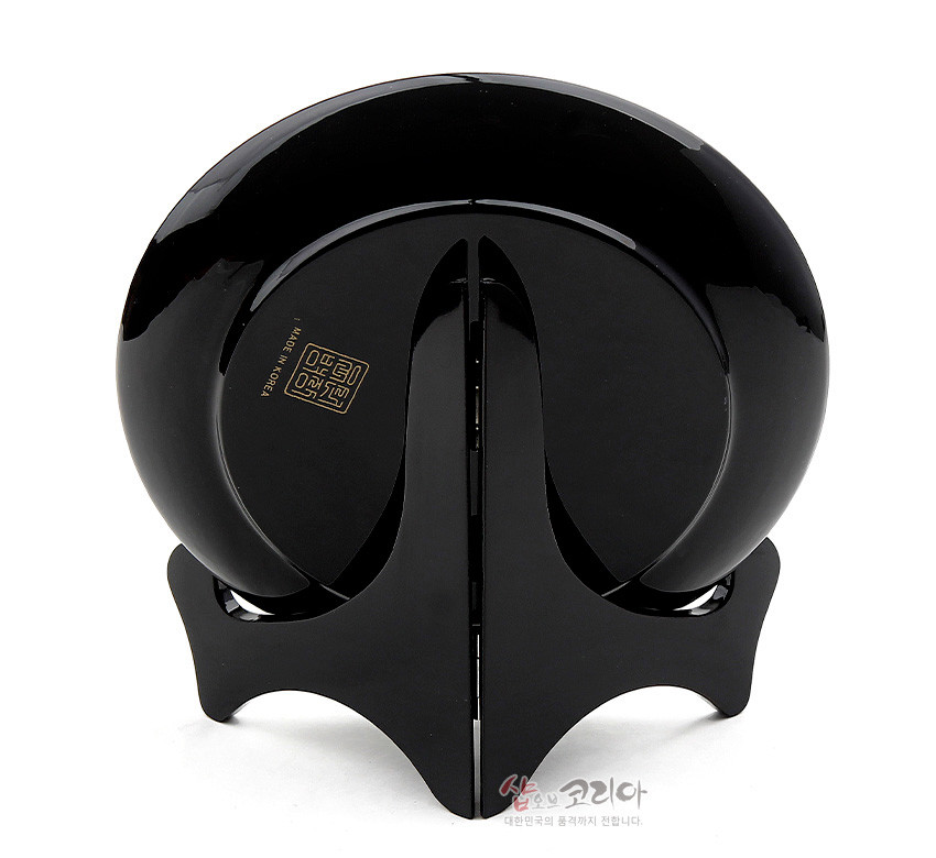 [텍스트: MADE IN KOREA] 흑색 옻칠 마감된 원형 나전칠기 쟁반과 곡선형 목재 받침대의 후면 디자인 모습