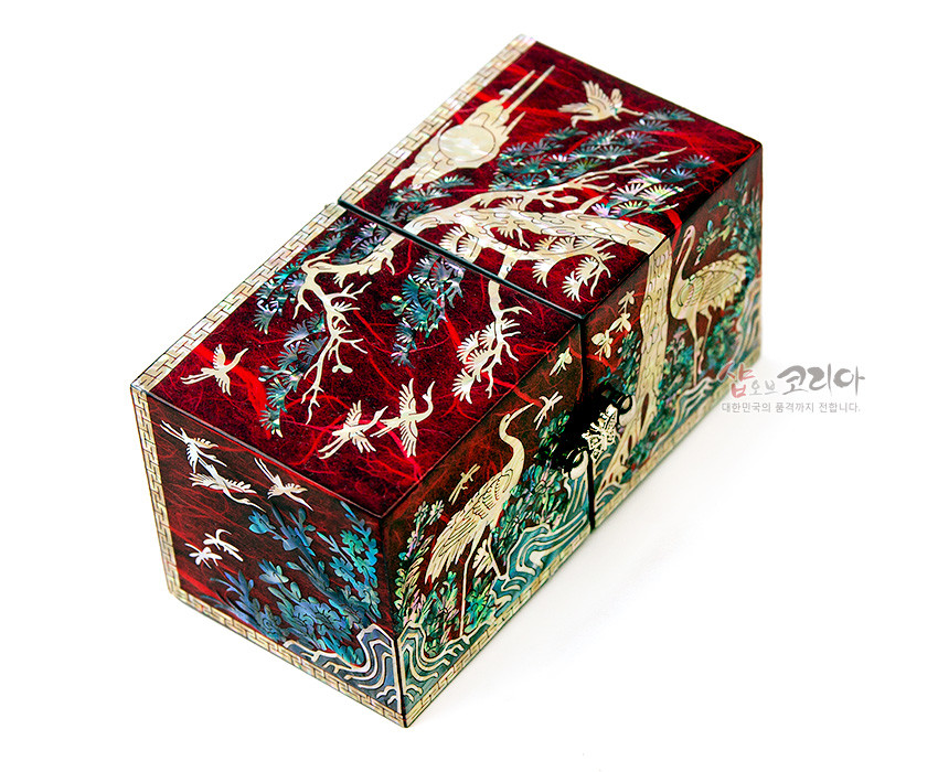 [텍스트: 샵오브코리아 대한민국의 품격까지 전합니다.] 붉은 옻칠 바탕 위 자개 상감 기법으로 송학과 소나무, 파도와 구름 문양을 섬세하게 표현한 전통 한지 쌍합 장식품