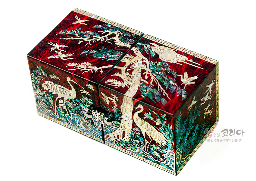 [텍스트: 샵오브코리아 대한민국의 품격까지 전달합니다.] 붉은 옻칠 바탕 위 자개 상감 기법으로 소나무와 학, 구름과 해 문양을 정교하게 표현한 전통 한지 쌍합 보석함 디자인