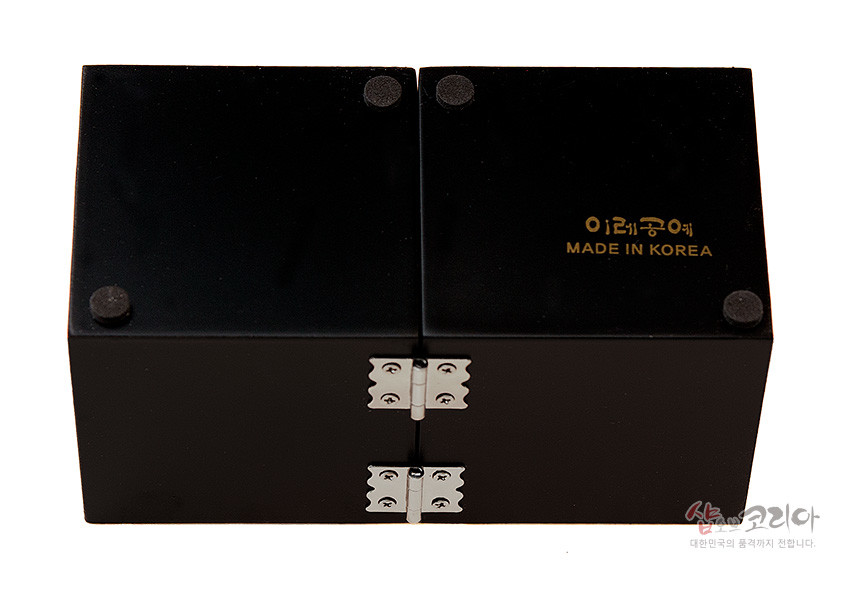 [텍스트: MADE IN KOREA] 매끄러운 흑색 옻칠 표면과 모서리 완충 패드, 중앙 금속 경첩이 보이는 쌍합 바닥면 디테일 표현