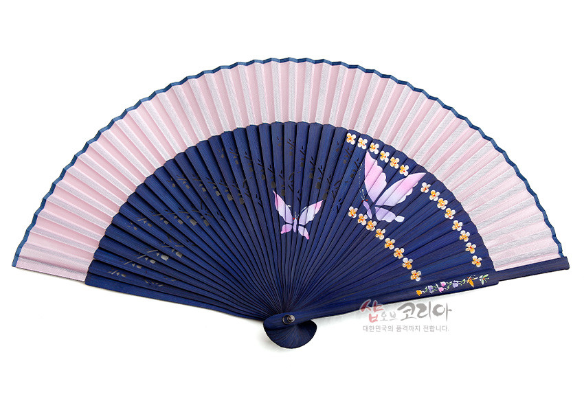 [텍스트: 샵오브코리아 대한민국의 품격까지 전합니다.] 남색 대와 분홍색 실크 접선 조합, 남색 면에 수공으로 표현된 나비와 노랑 꽃무늬 장식의 전통 실크 부채 디자인