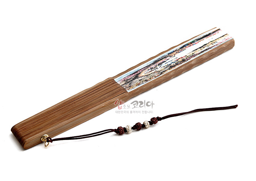 [텍스트: 샵오브코리아 대한민국의 품격까지 전합니다.] 대나무살 구조에 종이 재질 결혼풍속도 채색, 손잡이 끝 매듭 끈과 금속 고리 장식 전통 접선