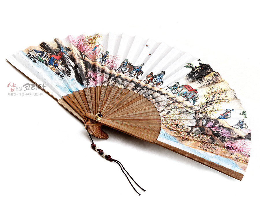 [텍스트: 샵오브코리아 대한민국의 품격까지 전해니다. ART OF KOREA copyright korea] 대나무살 구조 위에 흰 종이 펼침면, 한국 전통 결혼 행렬과 산수 풍속도를 다채로운 채색으로 표현하고 매듭 장식과 구슬을 단 전통 접선 디자인