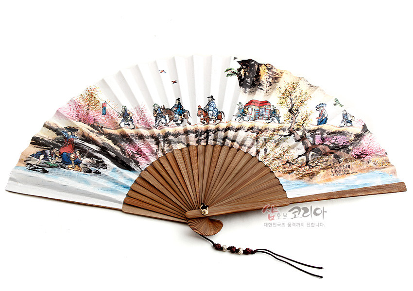 [텍스트: 샵오브코리아 대한민국의 품격까지 전합니다.] 대나무살과 백색 종이 위에 채색으로 표현된 전통 결혼풍속도와 산수 풍경, 하단 매듭과 구슬 장식이 어우러진 접선