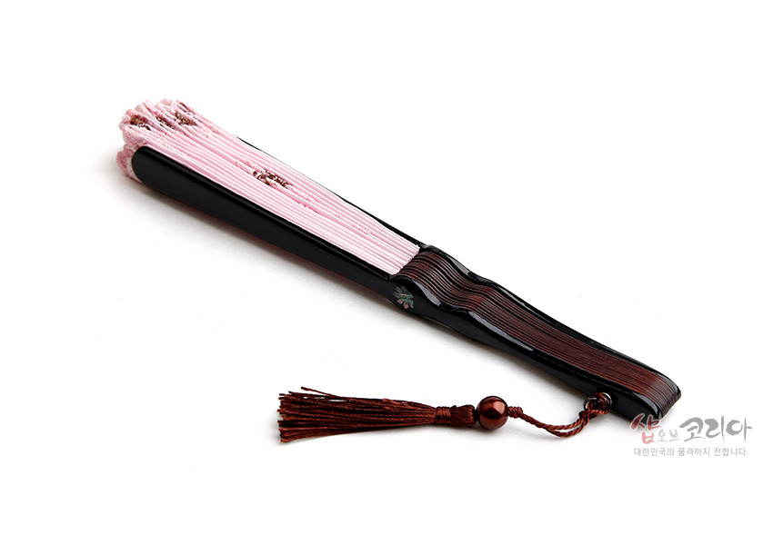 [텍스트: 샵오브코리아 대한민국의 품격까지 전합니다.] 연분홍 비단 부채살과 흑색·갈색 나무살, 자개 포인트와 브라운 매듭 술 장식 조화 이미지
