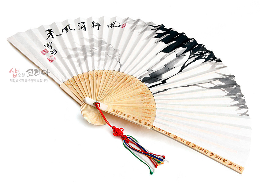 [텍스트: 샵오브코리아 대한민국의 품격까지 전합니다] 대나무살 구조 위 한지에 수묵으로 대나무와 먹산 풍경을 그린 합죽선, 붉은 매듭과 오방색 술 장식 특징