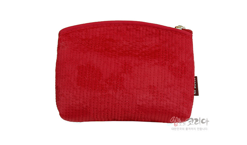[텍스트: 샵코리아 대한민국의 품격까지 전합니다.] 선명한 붉은 색 직사각형 패브릭 동전지갑, 세로 누비 기법과 은은한 광택이 도는 단색 천으로 제작된 지퍼 여밈 소품