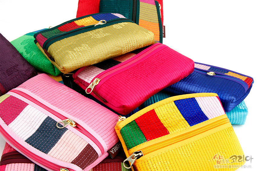 [텍스트: SHOP KOREA] 색동천을 세로 누비 기법으로 마감한 직사각형 동전지갑 모음, 지퍼 여밈과 원색 대비 색동 배색이 돋보이는 패브릭 소품 구성