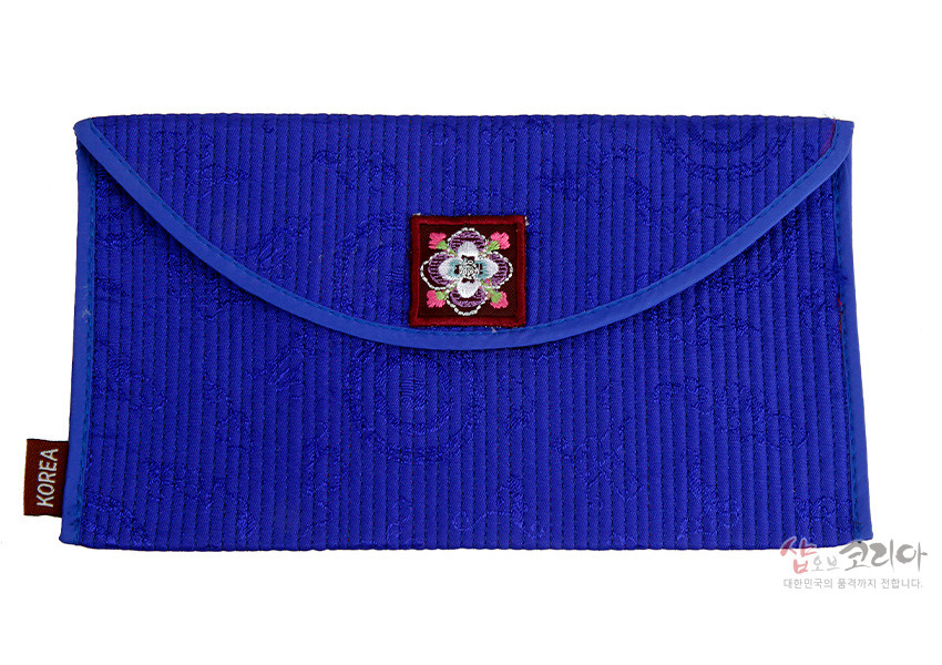 [텍스트: KOREA] 푸른색 누비 비단 소재의 봉투형 예단지갑, 앞면 중앙 꽃자수 문양 장식과 세로줄 누빔 무늬가 돋보이는 전통 공예품 형식