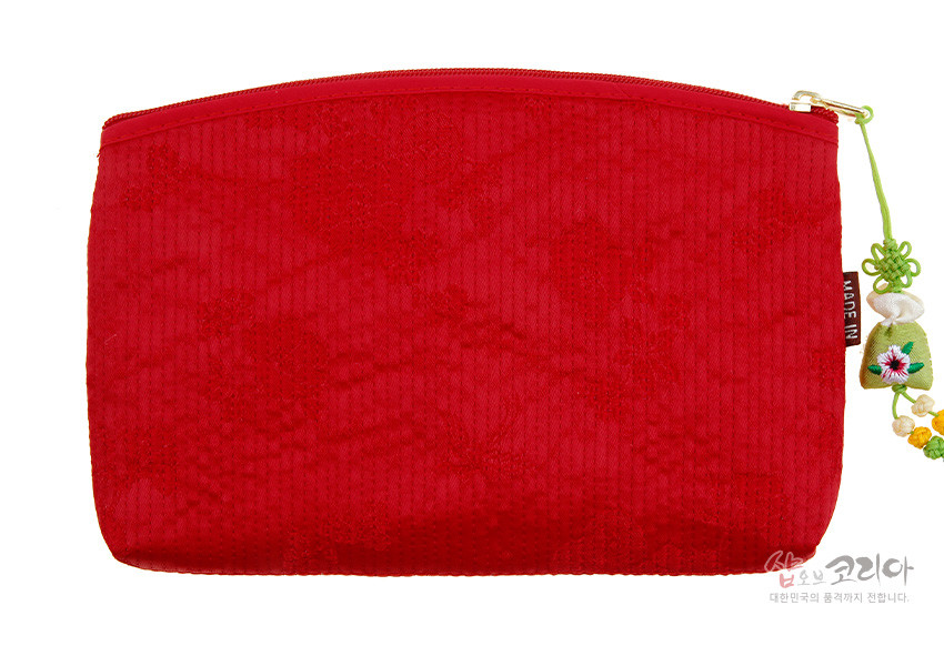 [텍스트: MADE IN] 붉은색 누비 원단에 은은한 꽃무늬 패턴과 금속 지퍼, 자수 매듭 장식이 조화를 이룬 직사각 파우치형 티슈지갑