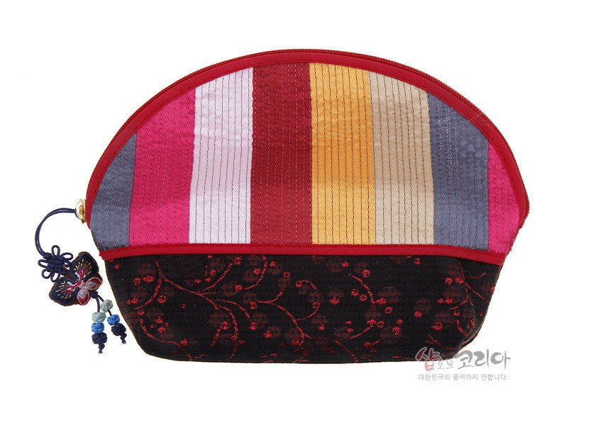 [텍스트: 샵코리아 대한민국의 품격까지 전합니다.] 색동 누비 비단으로 구성된 반원형 파우치, 검은 바탕 붉은 자수 꽃넝쿨 문양과 나비 매듭 장식, 옆면 지퍼 고리 장식 구성