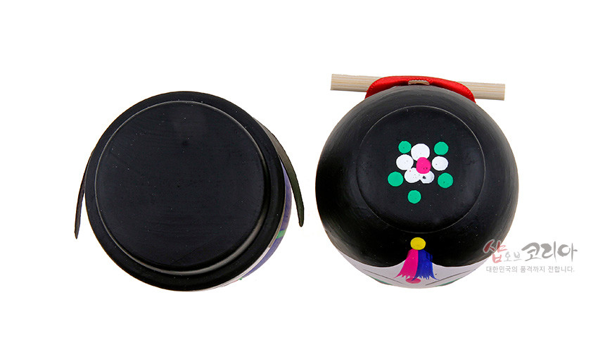 [텍스트: 샵오브코리아 대한민국의 품격까지 전달합니다.] 검은색 목재 표면에 아크릴 채색으로 연출한 원형 머리 장식과 꽃무늬 포인트, 색동 술 장식이 더해진 전통 혼례 신랑신부 목각 흔들인형 상단부 모습