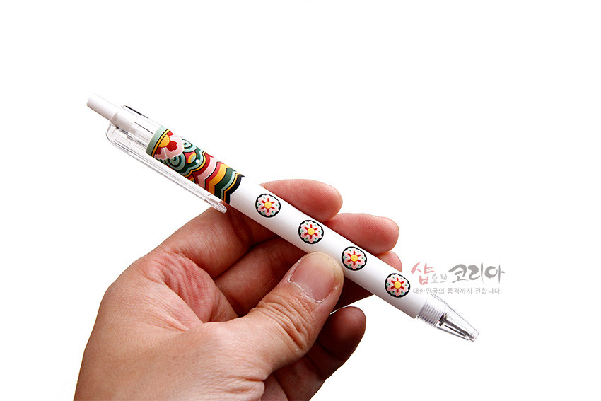[텍스트: 샵오브코리아 대한민국의 품격까지 전합니다.] 흰색 플라스틱 바디에 녹색·적색·황색 단청 곡선무늬와 반복된 원형 꽃문양이 인쇄된 젤펜 디자인