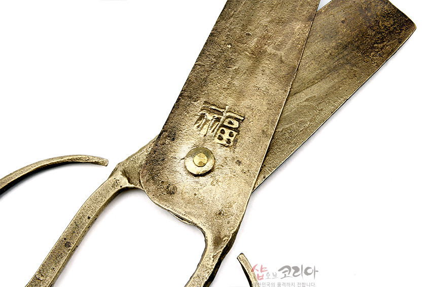 [텍스트: 福, 샵오브코리아] 황동빛 금속 재질 전통 엿가위, 거친 질감과 못 장식, 복 자 음각 문양이 새겨진 날과 곡선형 손잡이의 공예품 이미지