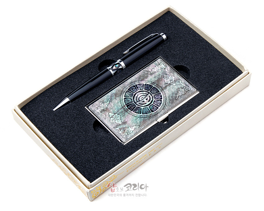 [텍스트: 샵오브코리아 대한민국의 품격까지 전합니다.] 은은한 빛의 자개 상감 운문부 원형 문양 금속 명함케이스와 흑색 금속 장식 볼펜 세트 모습