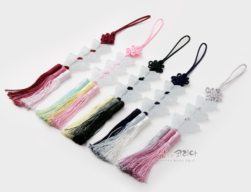 [텍스트: 샵오브코리아 대한민국의 품격까지 전달합니다.] 반투명 유리 느낌의 나비 장식 3단과 색실 매듭, 그러데이션 비단 삼단 술이 조화를 이룬 전통 노리개 장식
