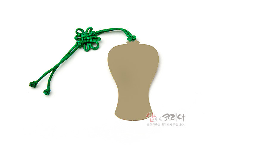 [텍스트: 샵오브코리아 대한민국의 즐거까지 전합니다.] 금속 재질 매병 실루엣 책갈피와 초록색 전통 매듭 끈의 조화 모습