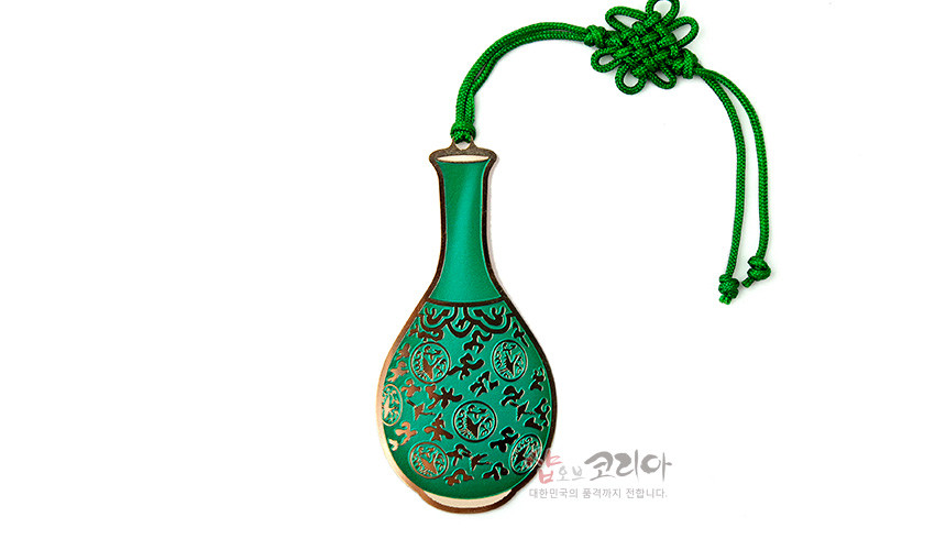 [텍스트: 샵오브코리아 대한민국의 품격까지 전합니다.] 금속 재질 청자 주병 형태 책갈피, 녹색 바탕에 검은색 덩굴문과 원형 문양 채색, 상단 전통 매듭 기법의 녹색 끈 장식