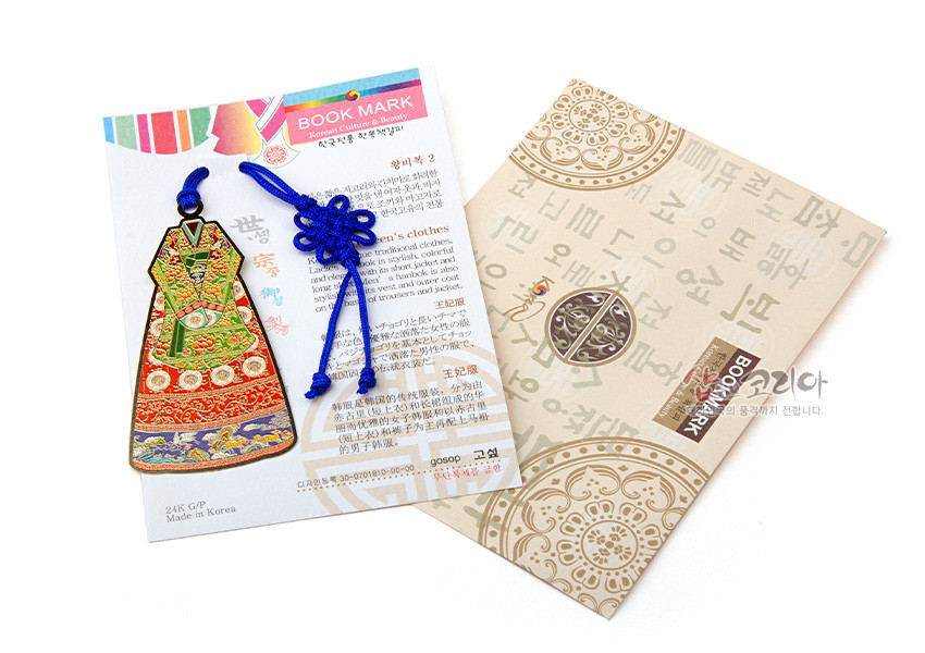 [텍스트: BOOK MARK, Korean Culture & Beauty, 왕비복 2, women’s clothes, 24K G/P, Made in Korea] 금속 재질의 왕비복 형상 책갈피, 붉은색과 녹색 에나멜 채색, 용·학 전통 문양과 청색 전통 매듭끈 장식 구성