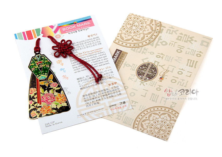 [텍스트: BOOK MARK, 24K GP, Made in Korea, 샵코리아 대한민국의 품격까지 전합니다] 금속 재질 한복 여인 형상 책갈피, 녹색 저고리와 흑색 치마 위 금색·적색 꽃문양 에나멜 채색, 붉은 전통 매듭끈 장식 구성