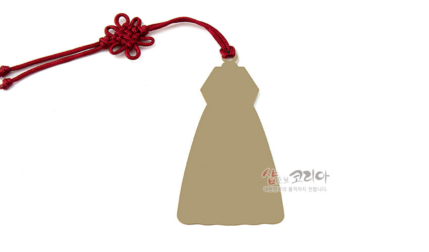 [텍스트: 샵오브코리아 대한민국의 품격까지 전합니다.] 금속 재질 한복 실루엣 책갈피와 붉은색 전통 매듭끈 장식이 어우러진 단색 뒷면 디자인
