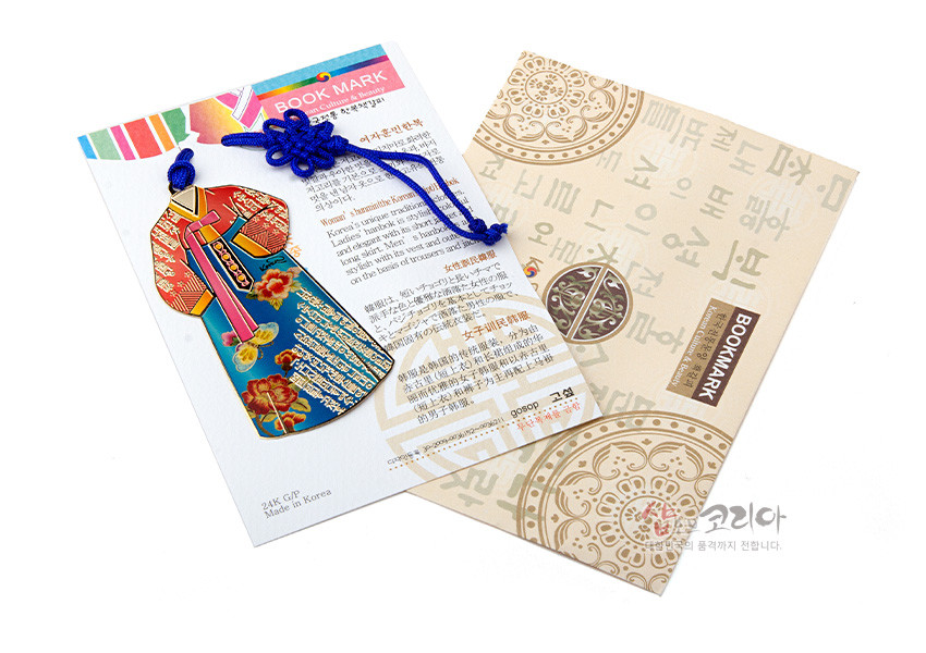 [텍스트: BOOK MARK, 24K GP, Made in Korea, BOOKMARK] 금속 재질 24K 도금 한복 형상 책갈피와 청색 전통 매듭끈, 꽃문양과 훈민정음 글자 장식 카드형 포장 구성 이미지
