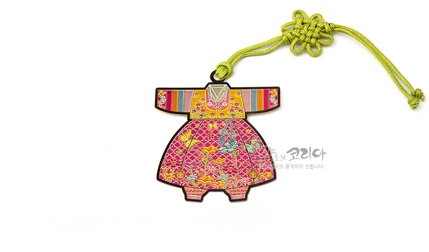 [텍스트: 샵오브코리아] 금속 재질 위 채색 기법으로 표현된 아동색동한복 책갈피, 분홍 바탕 꽃문양과 색동 소매, 연두색 전통 매듭 장식 구성