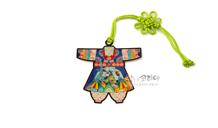 [텍스트: 샵오브코리아 한국의 품격까지 전합니다.] 금속 재질 위 채색 기법으로 표현된 아동 색동한복 모양 책갈피, 청색·홍색·노랑 색동과 전통 문양, 연두색 매듭 장식 조화된 디자인