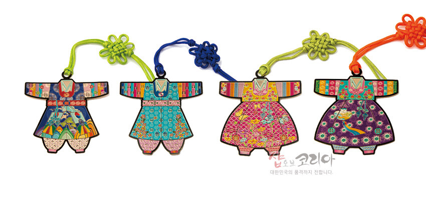 [텍스트: 샵오브코리아 대한민국의 품격까지 전합니다.] 금속 재질 위 채색 기법으로 표현된 아동 색동한복 모양 책갈피 4종, 색동 소매와 꽃·학 전통 문양, 형형색색 매듭 장식 구성